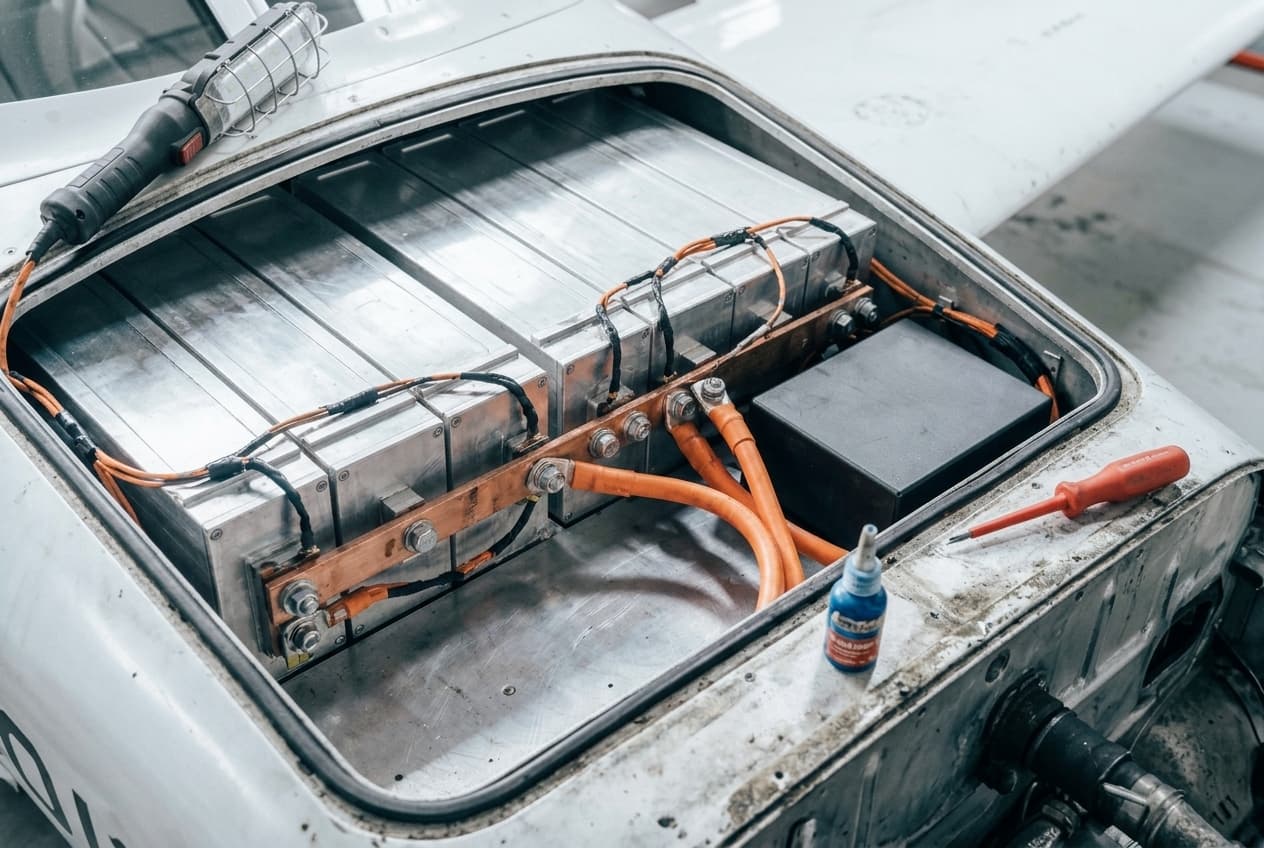 Geöffneter Energieraum mit Batteriemodulen in Aluminiumgehäusen und orangen Hochvoltkabeln